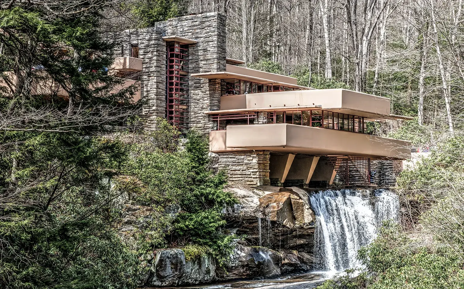 house with waterfall at base
