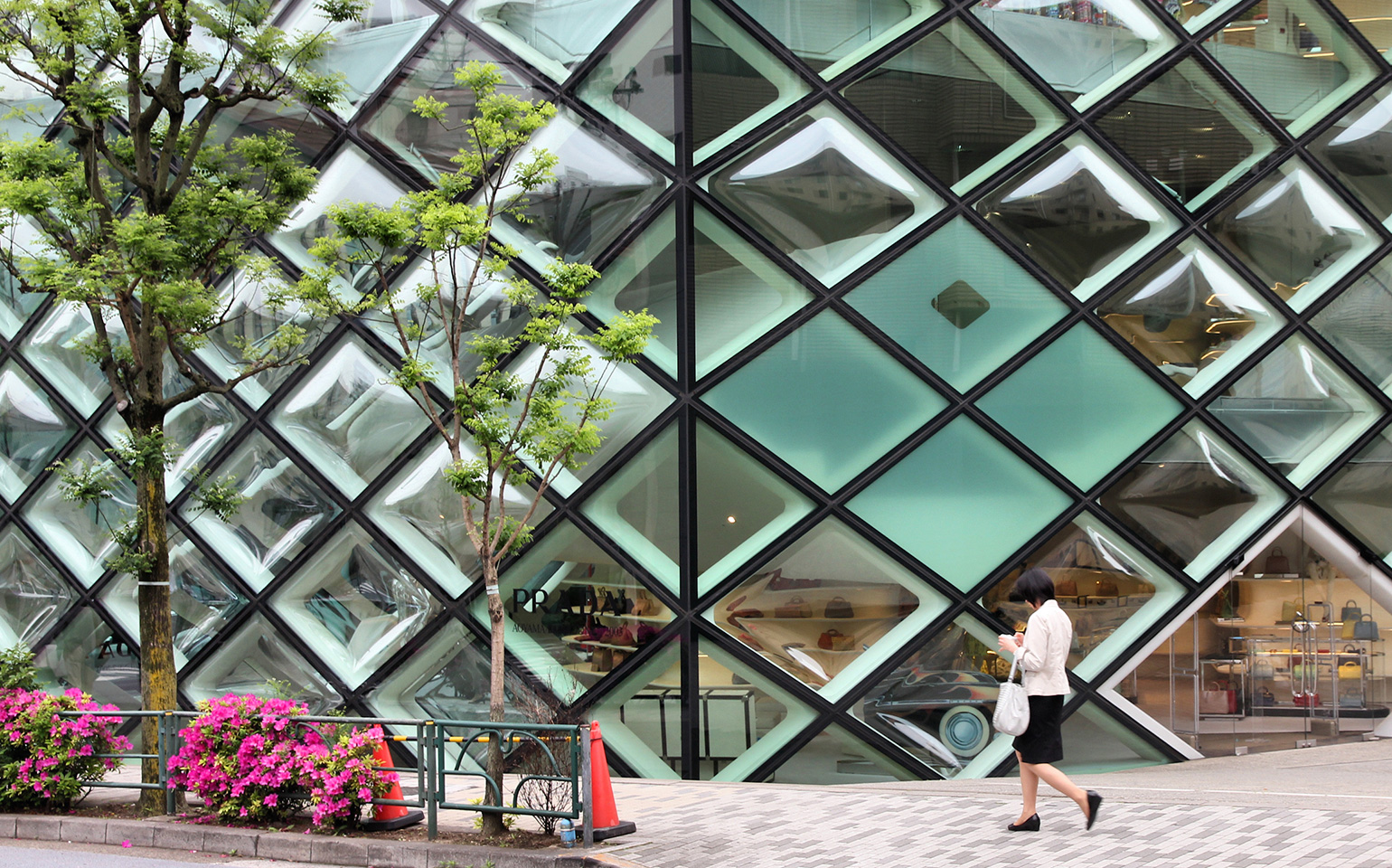 Woman Walking in front of glass building