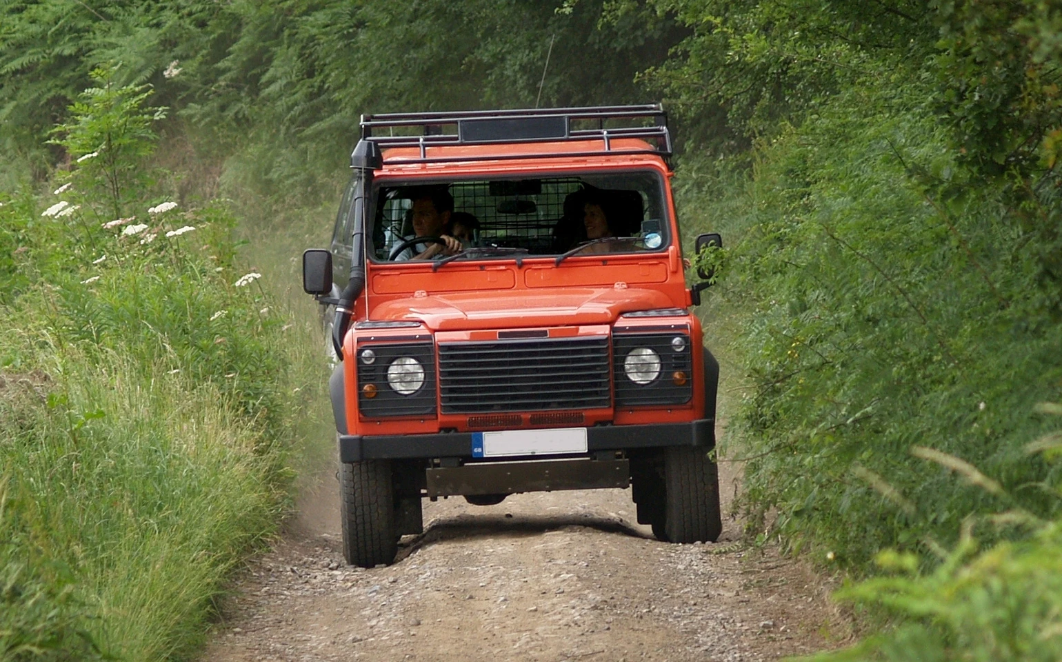red Land Rover on a dirt road