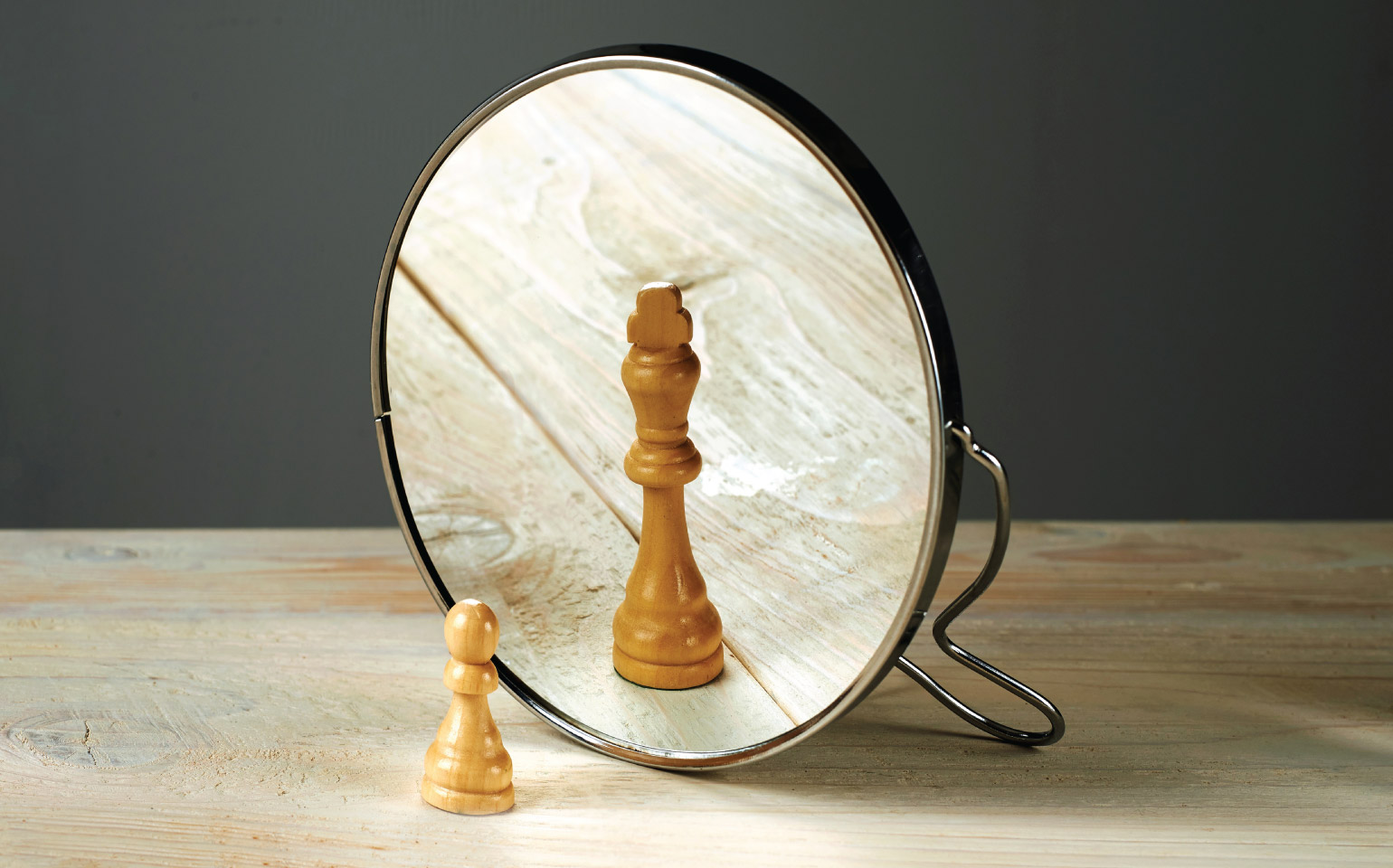 chess pawn in front of mirror reflection of a king