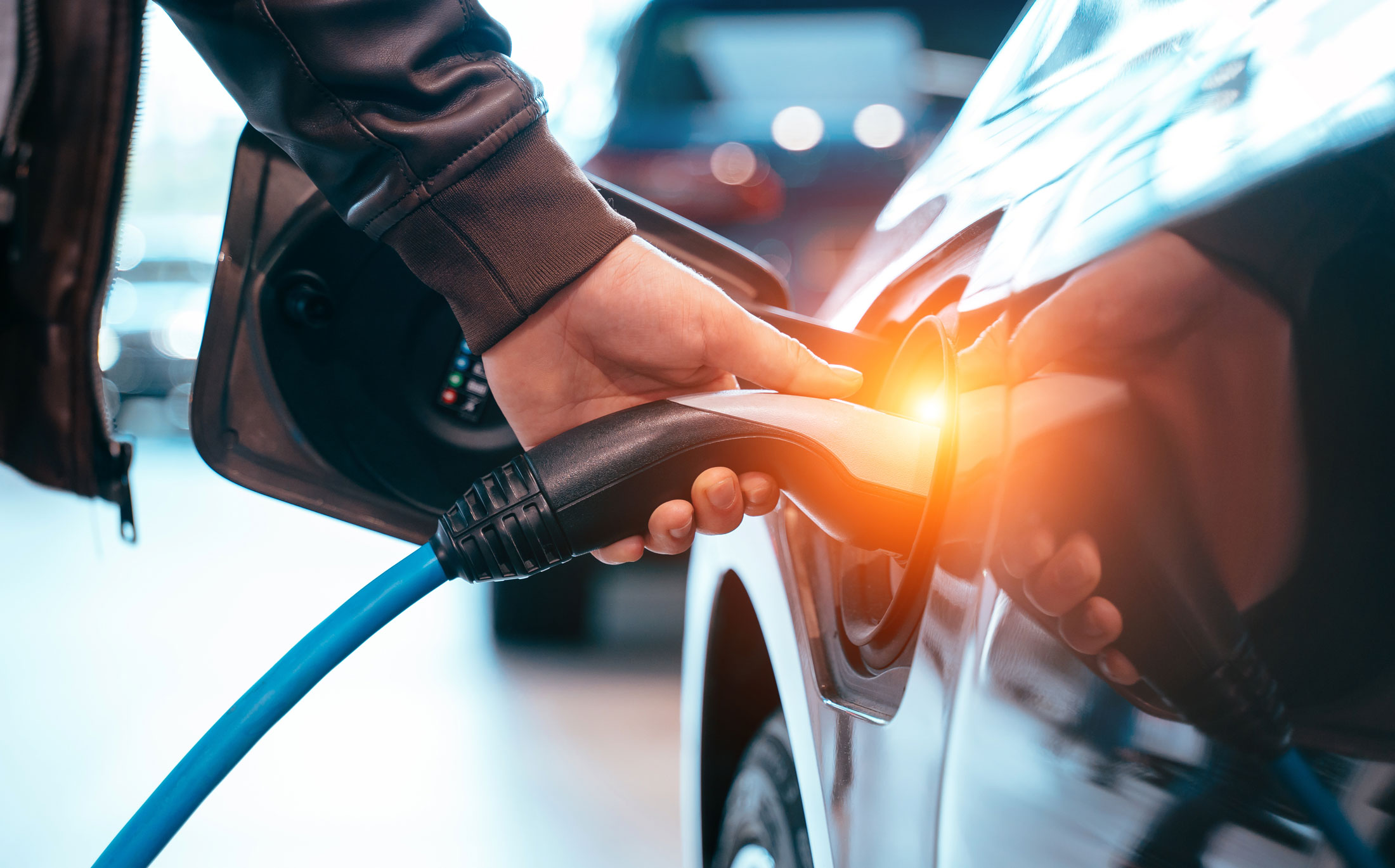 man plugging in an electric vehicle