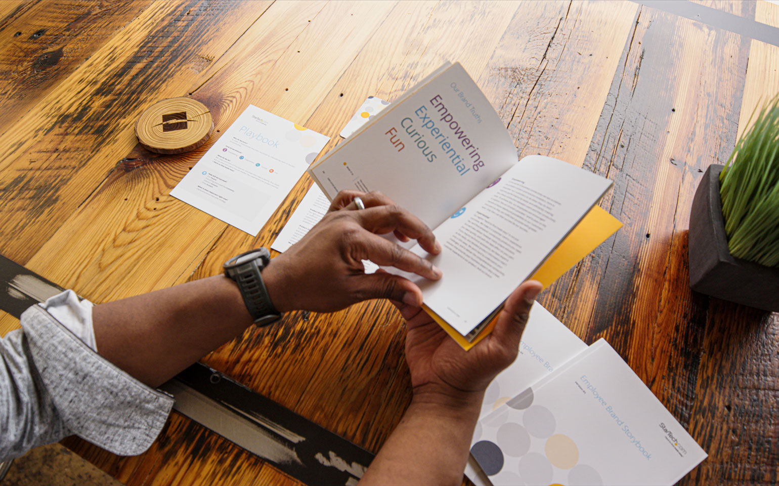 man holding a book at a wooden table