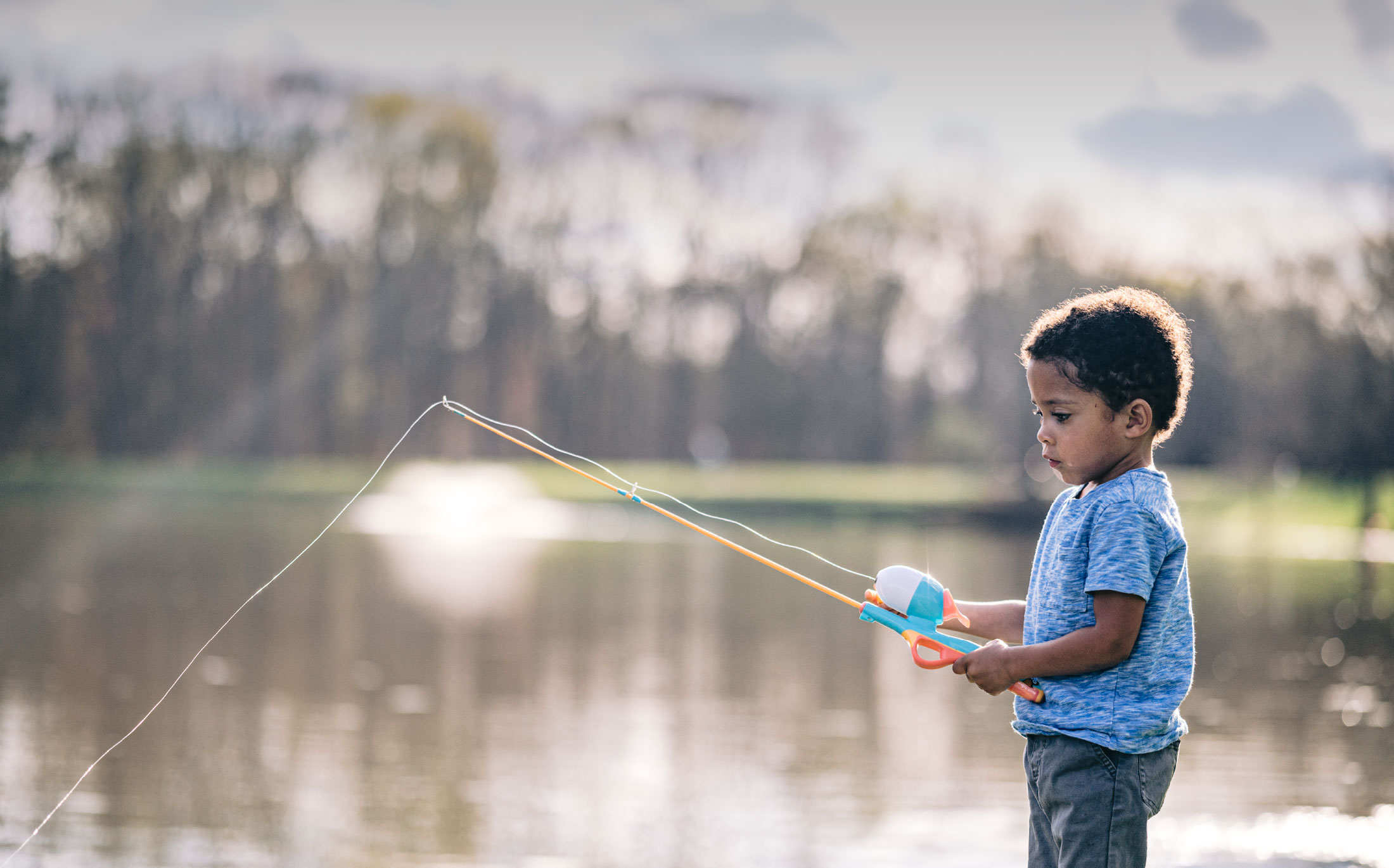 child fishing by a lake