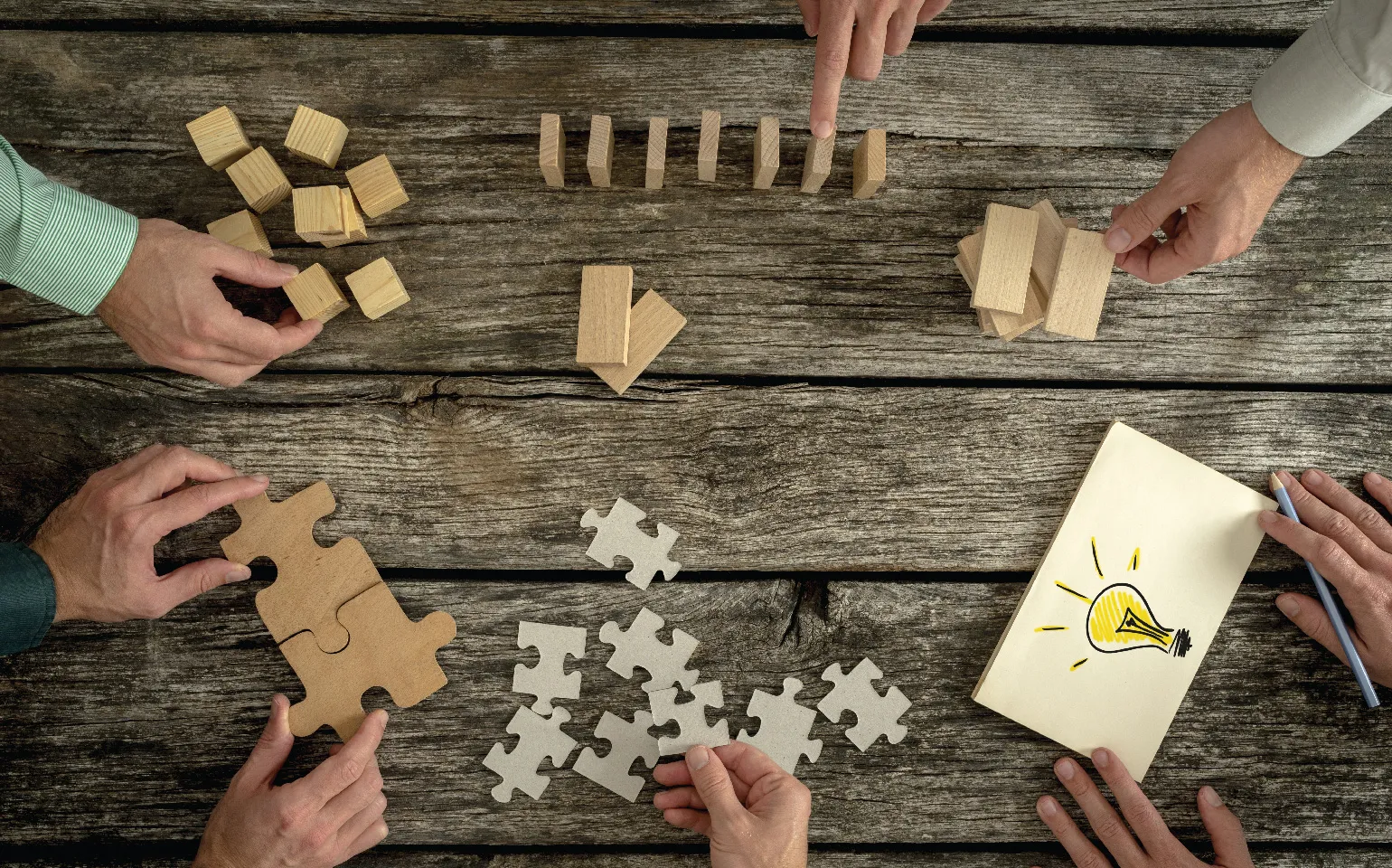 hands playing with blocks and puzzle pieces showing play encourages innovation