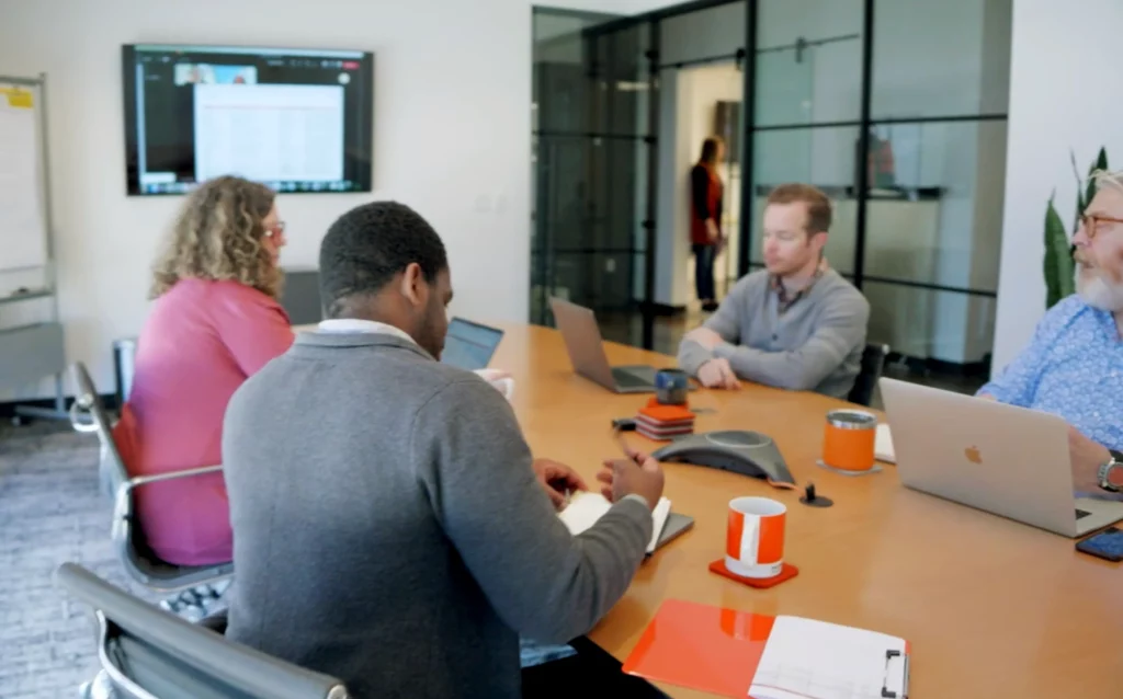 four people siting around a conference table