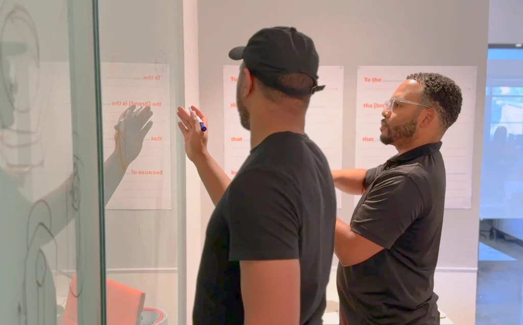 two men brainstorming at a whiteboard
