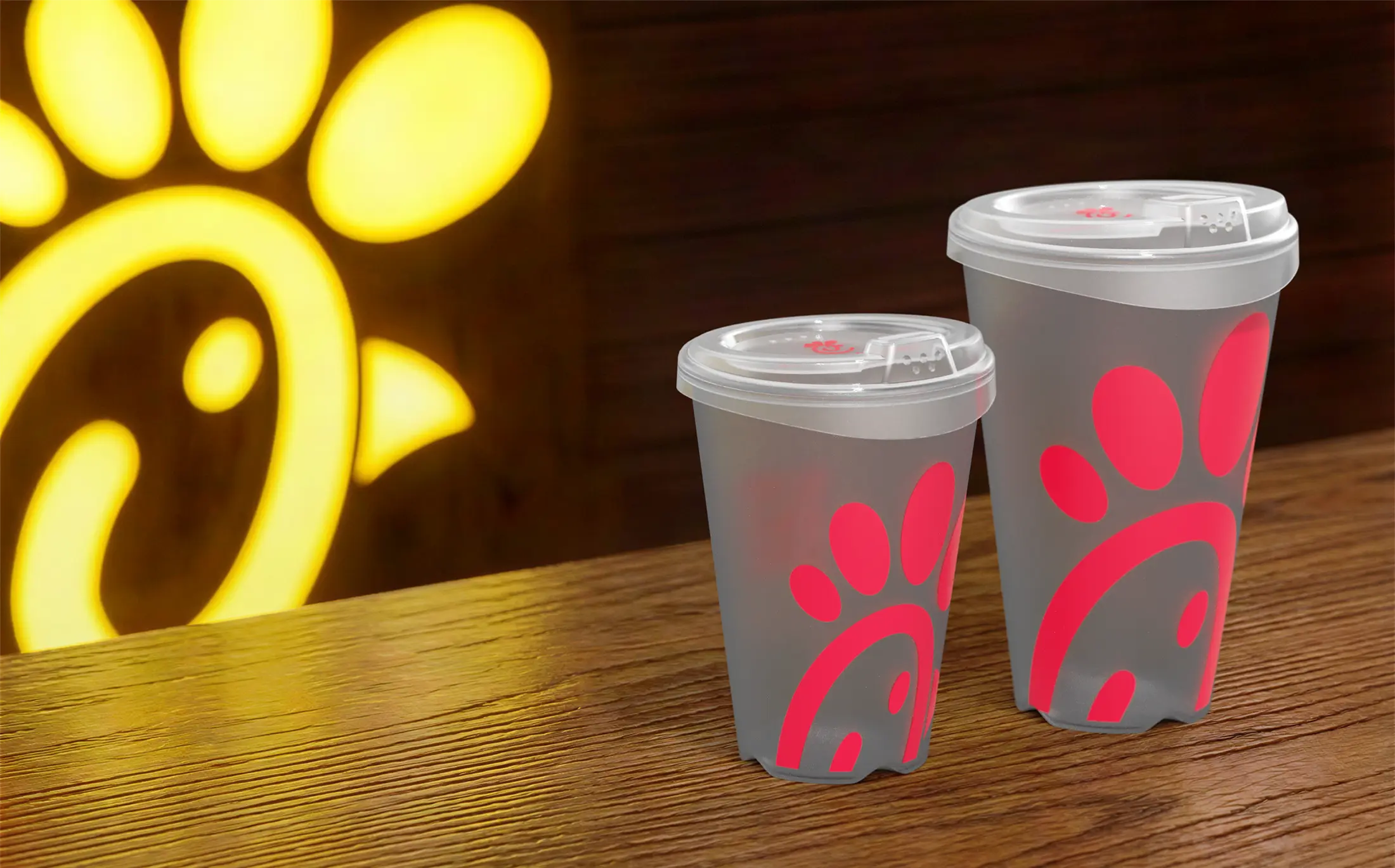 2 clear Chick-fil-A reusable cups filled with ice and soda on a table