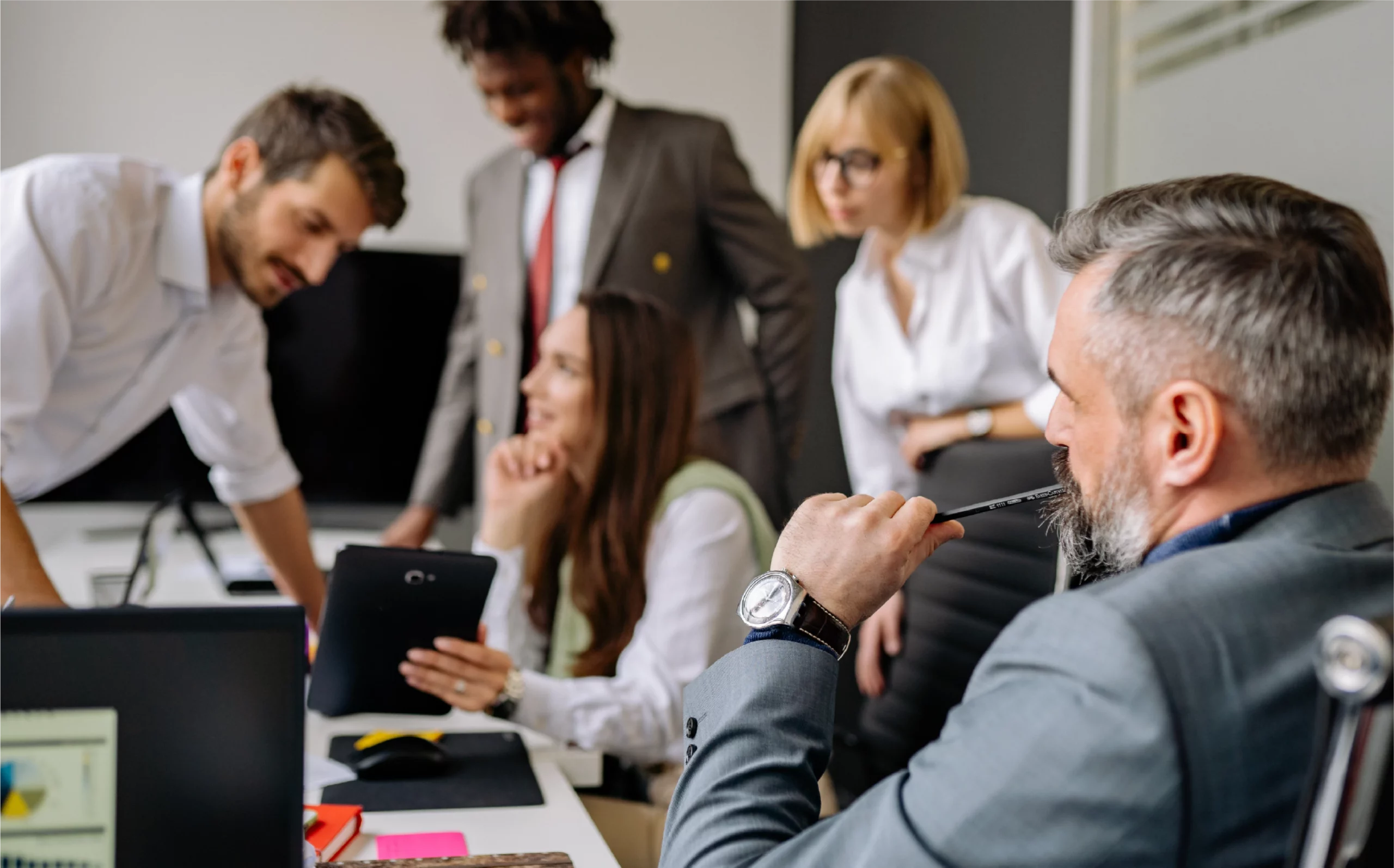 group of people in a room discussing a presentation in front of an executive