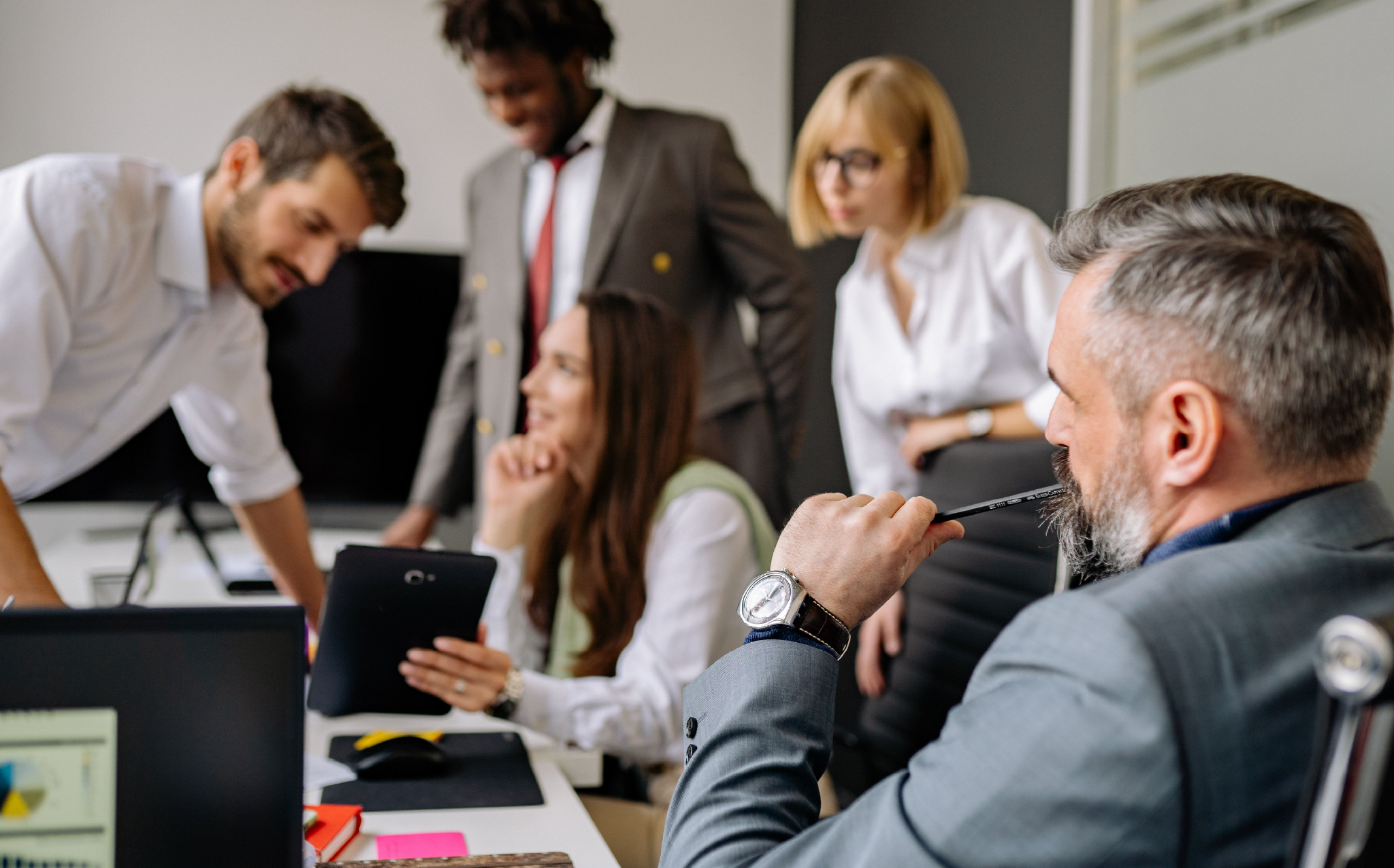 a group of people in a room discussing a presentation in front of an executive